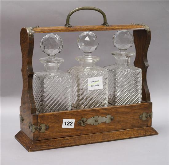 An Edwardian oak cased three bottle tantalus